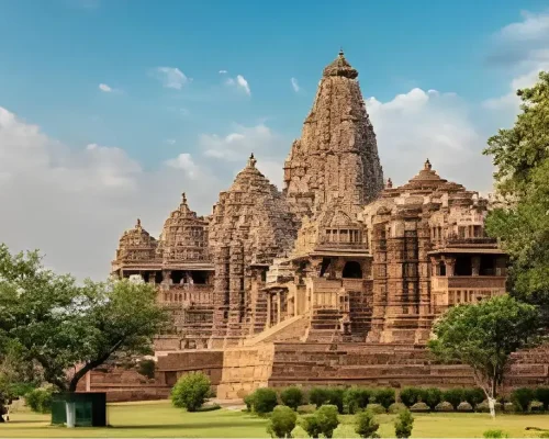 A masterwork of Nagara-style construction, the Kandariya Mahadev Temple in Khajuraho boasts a tall shikhara against a beautiful blue sky and elaborate sculptures.